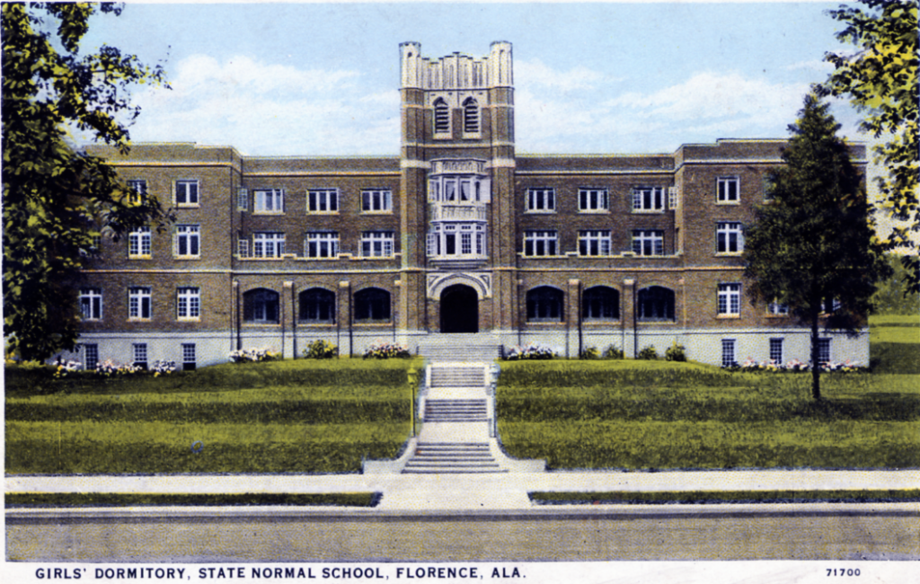 An antique postcard featuring an old dormitory building at UNA