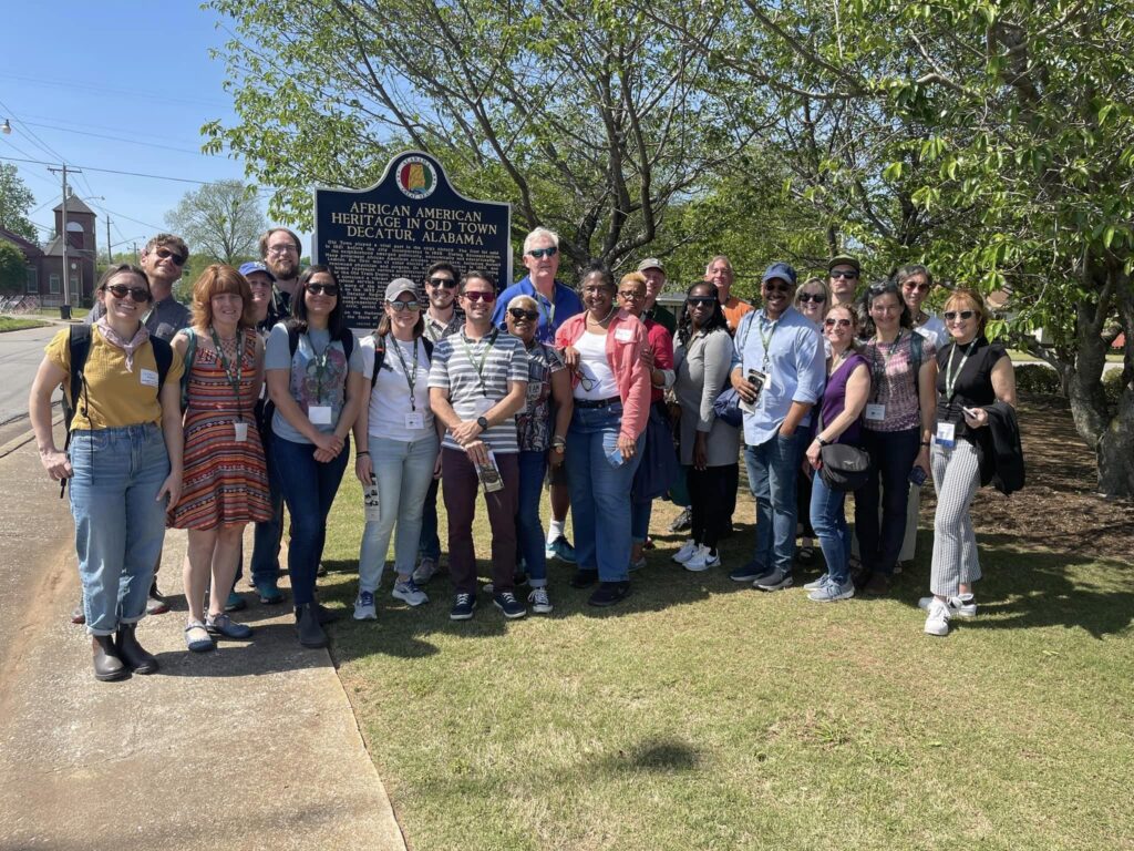 A group of visitors standing around an historical marker.