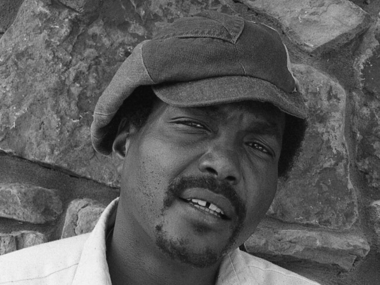 A black-and-white close-up of musician Arthur Alexander, showing the musician in a shirt & cap.
